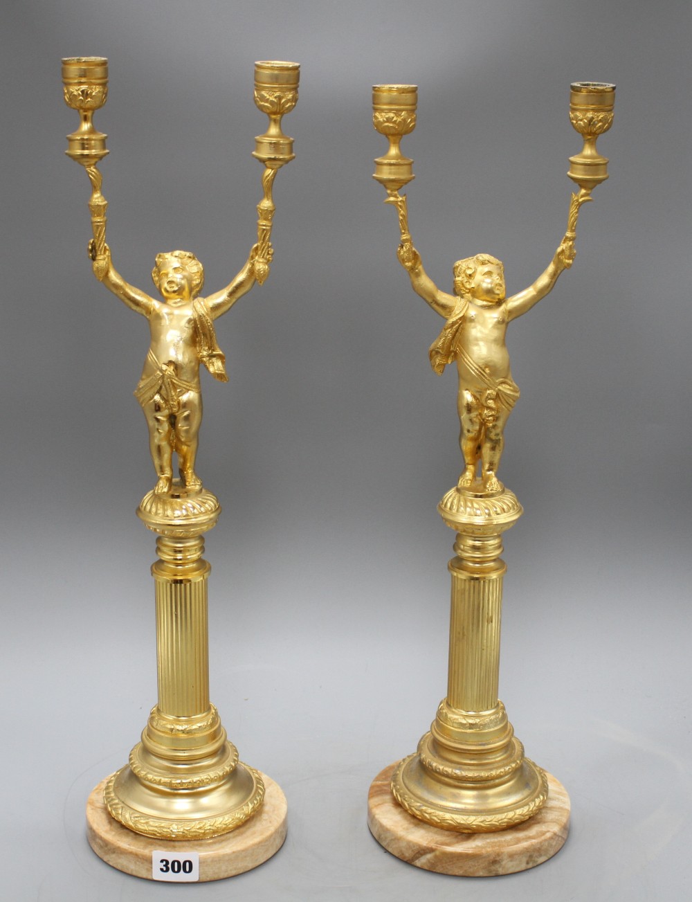 A pair of Italian gilt metal candelabra, with cherub stems and onyx bases, height 52cm